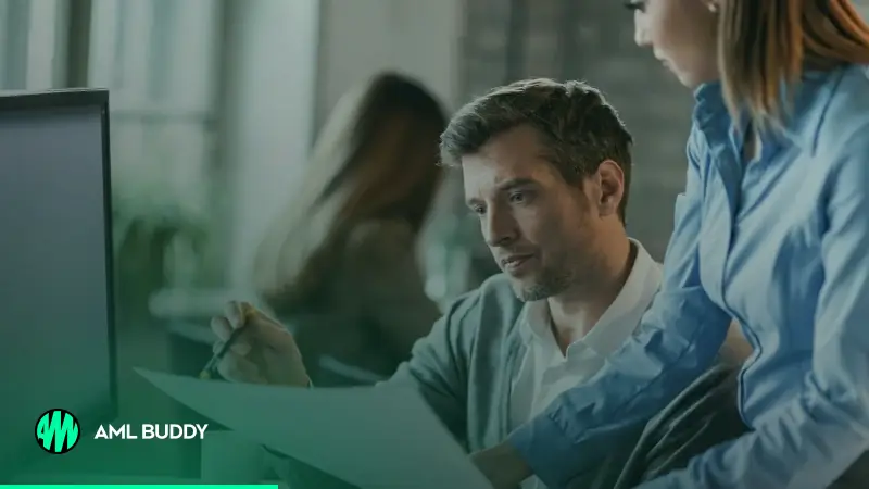 Two colleagues reviewing client documents together at an office desk