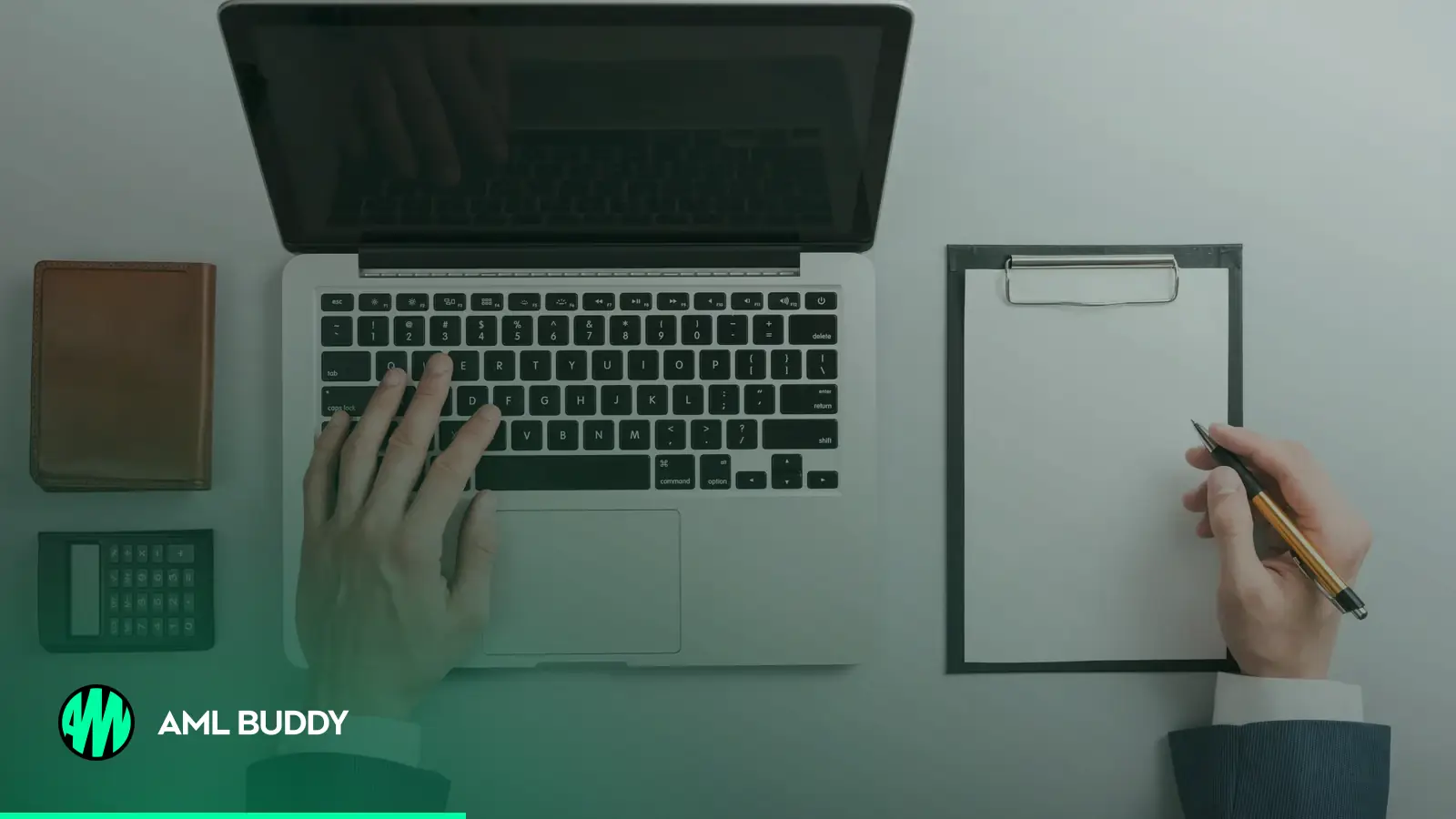 Hands working on a laptop next to a checklist on a clipboard